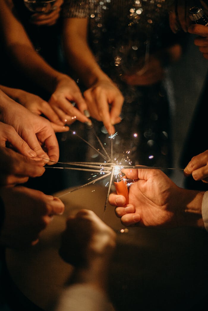 A group of people enjoying a festive celebration by lighting sparklers together.